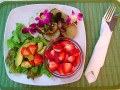 Caçarola vegetariana italiana de batatas temperadas com salada verão de abacate e morango